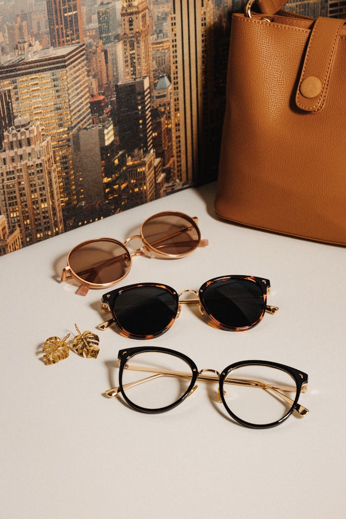 Chic sunglasses and handbag with NYC skyline backdrop, elegant fashion display.